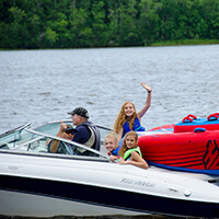 A family wearing life jackets, enjoys boating safely on the water.