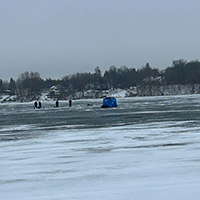 A group of people ice fishing on a lake.