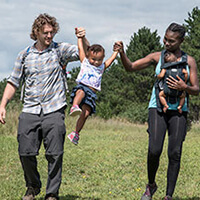 A family walks though a grassy field at William O'Brien State Park in Minnesota.